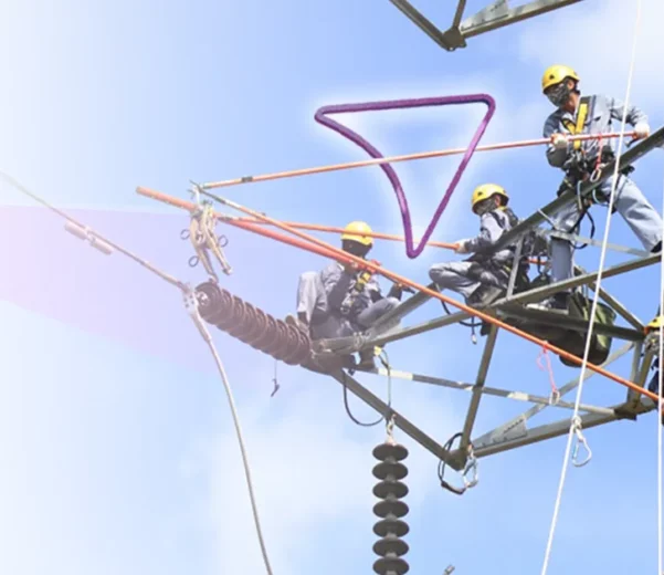 Techniciens travaillant en hauteur sur une tour électrique pour la maintenance préventive, utilisant des équipements de sécurité et des outils spécialisés pour assurer la gestion des actifs et des infrastructures de réseau