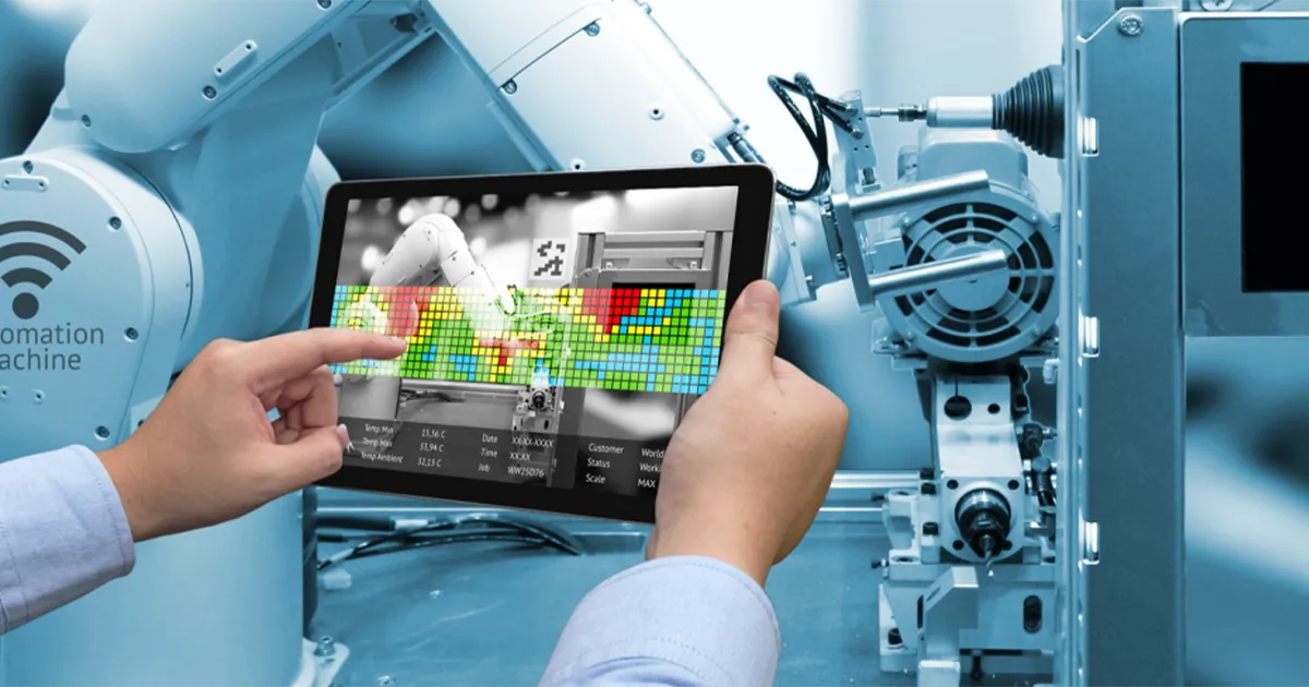 Technologie de maintenance prédictive : un technicien utilise une tablette pour analyser en temps réel les performances d’un bras robotisé connecté à l’IoT.