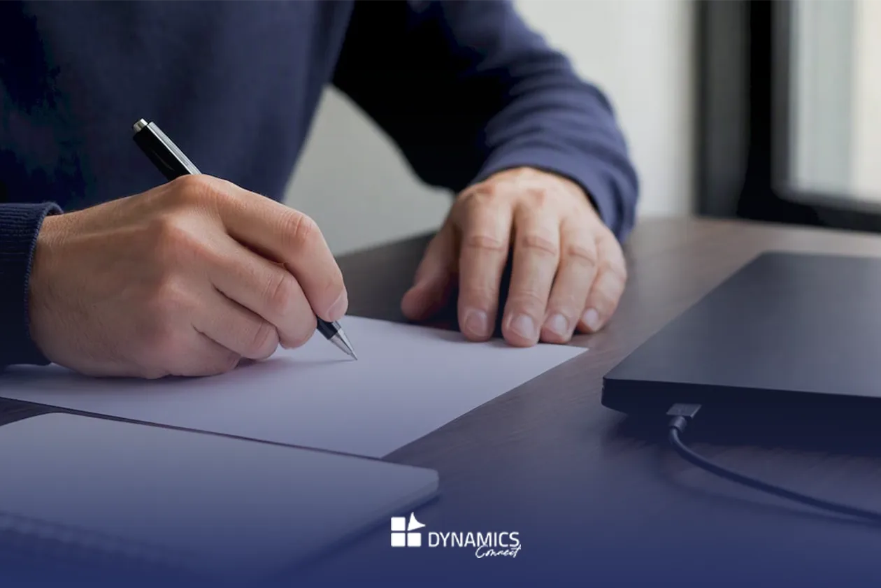 Des mains esquissent le plan d’un projet ERP sur un bureau, préparant chaque étape avec précision.