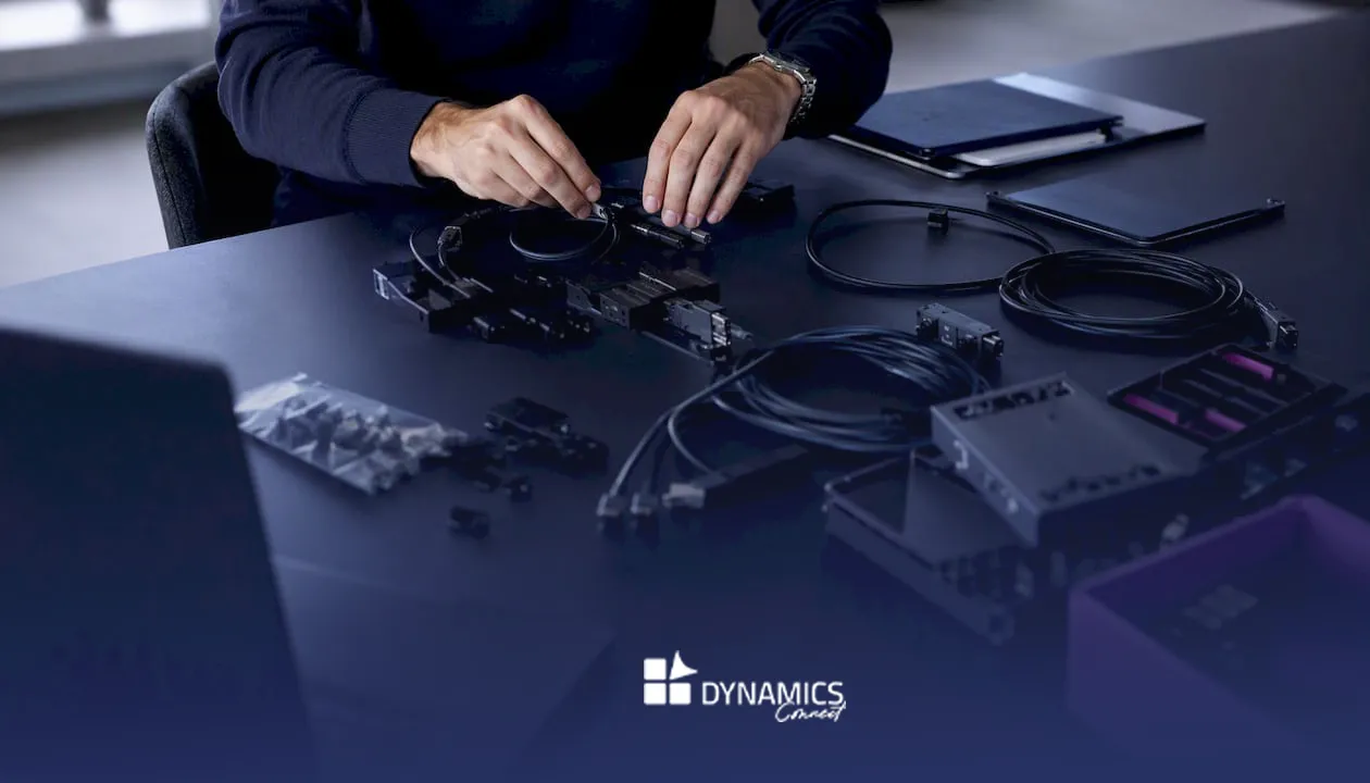 Des mains s’activent pour connecter des câbles modulaires lors de l’installation d’un système ALM.